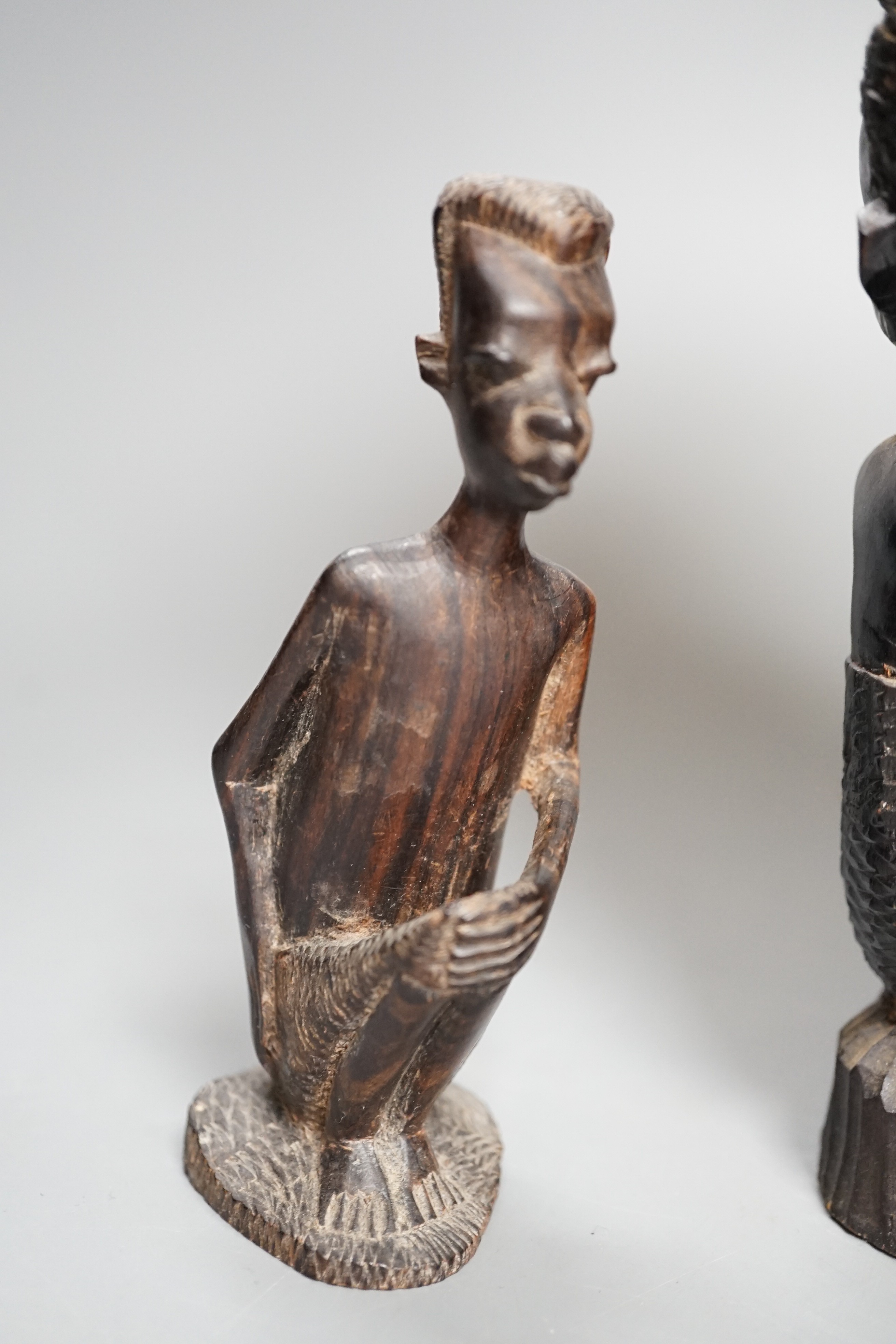 Four tribal hardwood carvings, two bows and two bronze spears longest 85cm